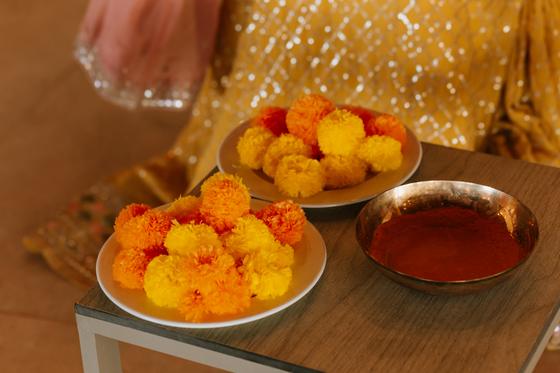 Bowls of marigolds and turmeric paste on a side table