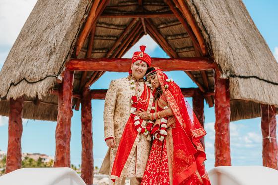 Couple beneath a thatched gazebo after the ceremony