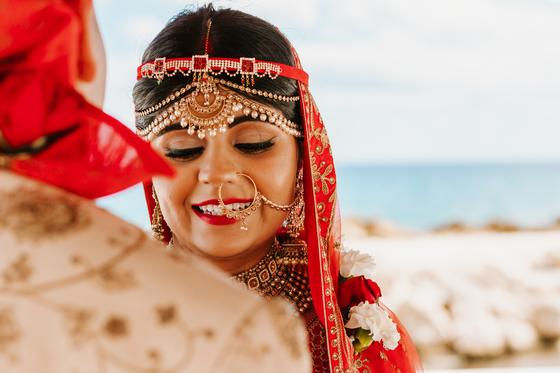 Bride's portrait in red, maang tikka and nath