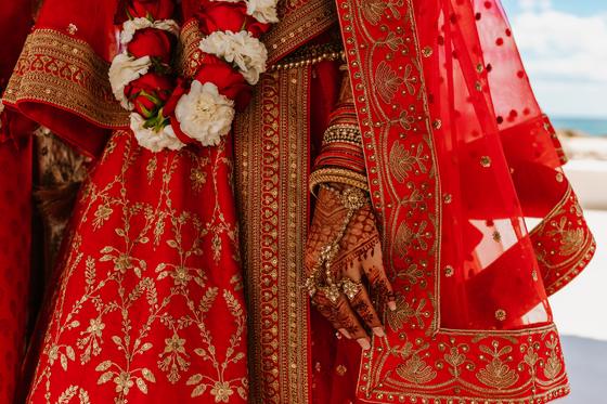 Bridal lehenga and henna-covered hands at rest