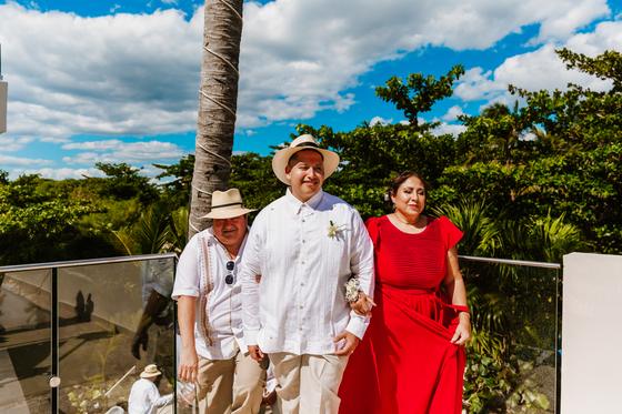 Guests in guayaberas and panama hats arriving for the ceremony