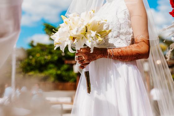 White lily bouquet held in henna-covered hands