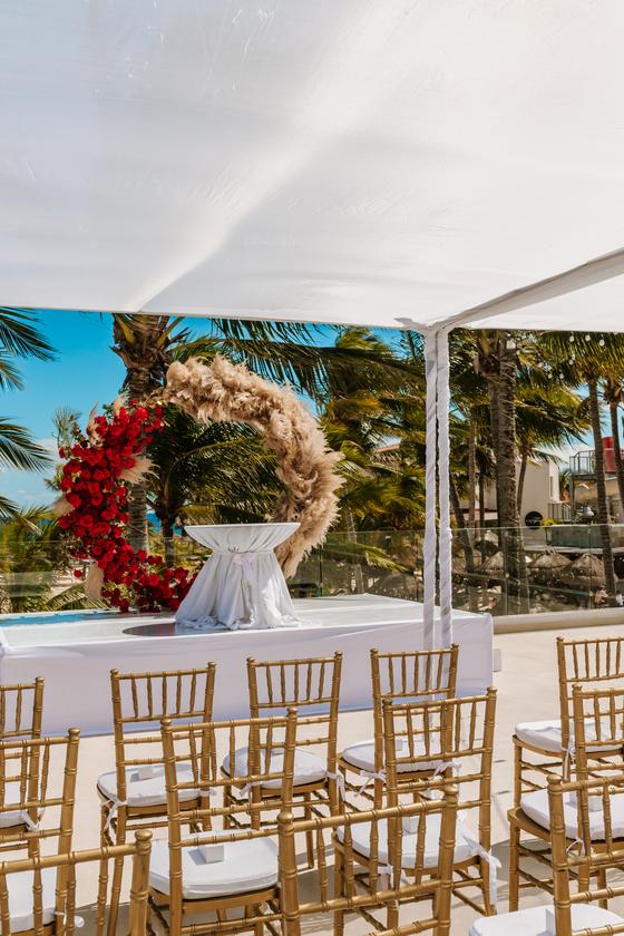 Ceremony chairs beside the pampas and bougainvillea arch