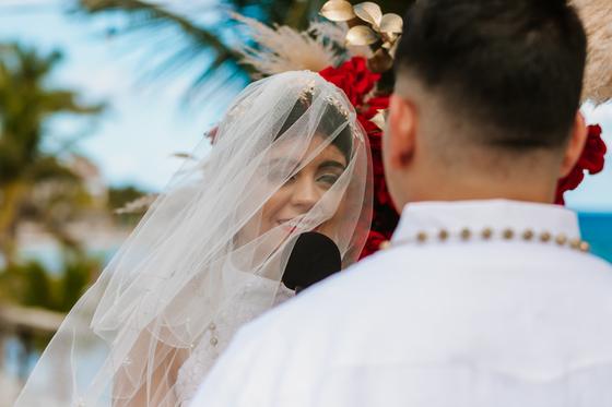 Bride's veil lifting in the wind beside the groom