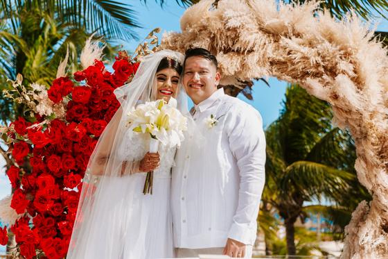 Couple with the bouquet under the flowers