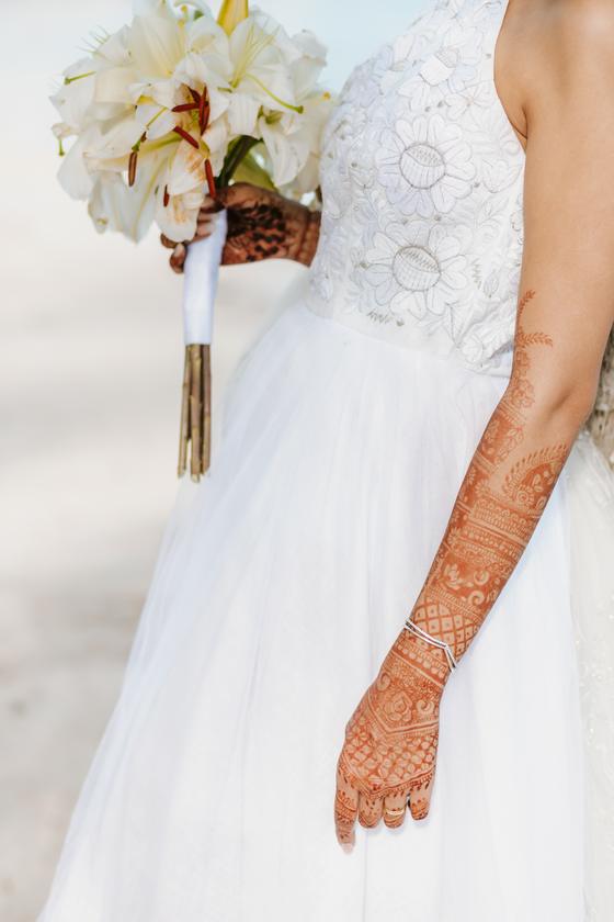 White bouquet held in henna-covered hands