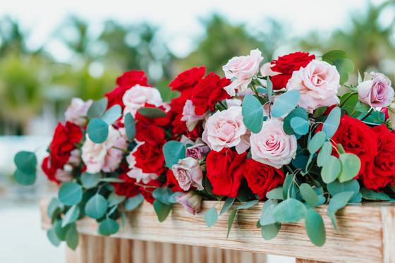 Box centrepiece of red and blush roses with eucalyptus