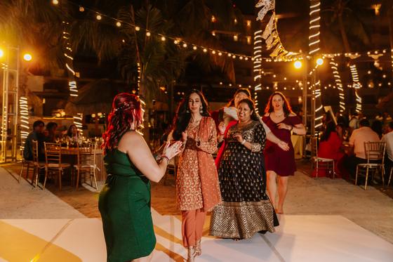 Guests dancing beneath strings of lights
