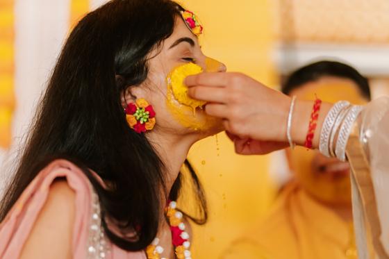Turmeric being applied to the bride during the haldi