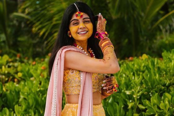 Bride laughing in her mehndi lehenga