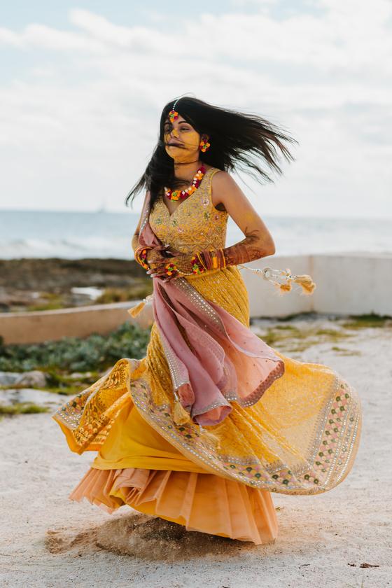 Bride mid-twirl on the sand in yellow