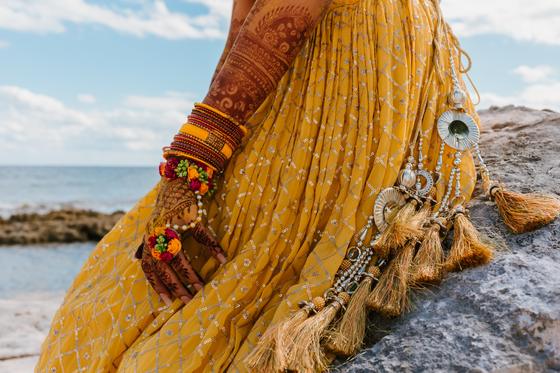 Yellow lehenga hem and bangles against the rock