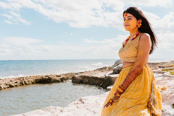 Bride seated on the rocks above the water