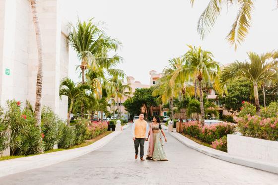 Couple walking a palm-lined resort road at golden hour