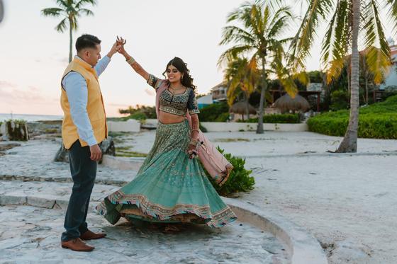 Groom turning the bride beneath the palms