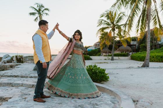 Bride mid-turn, lehenga flaring under the palms