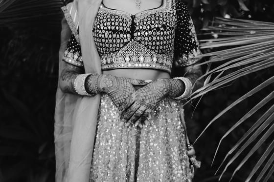 Black and white study of henna hands against palm fronds