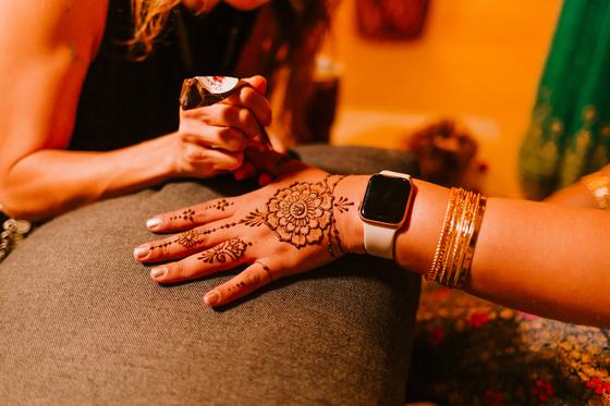 Henna-covered hand resting, bangles stacked at the wrist