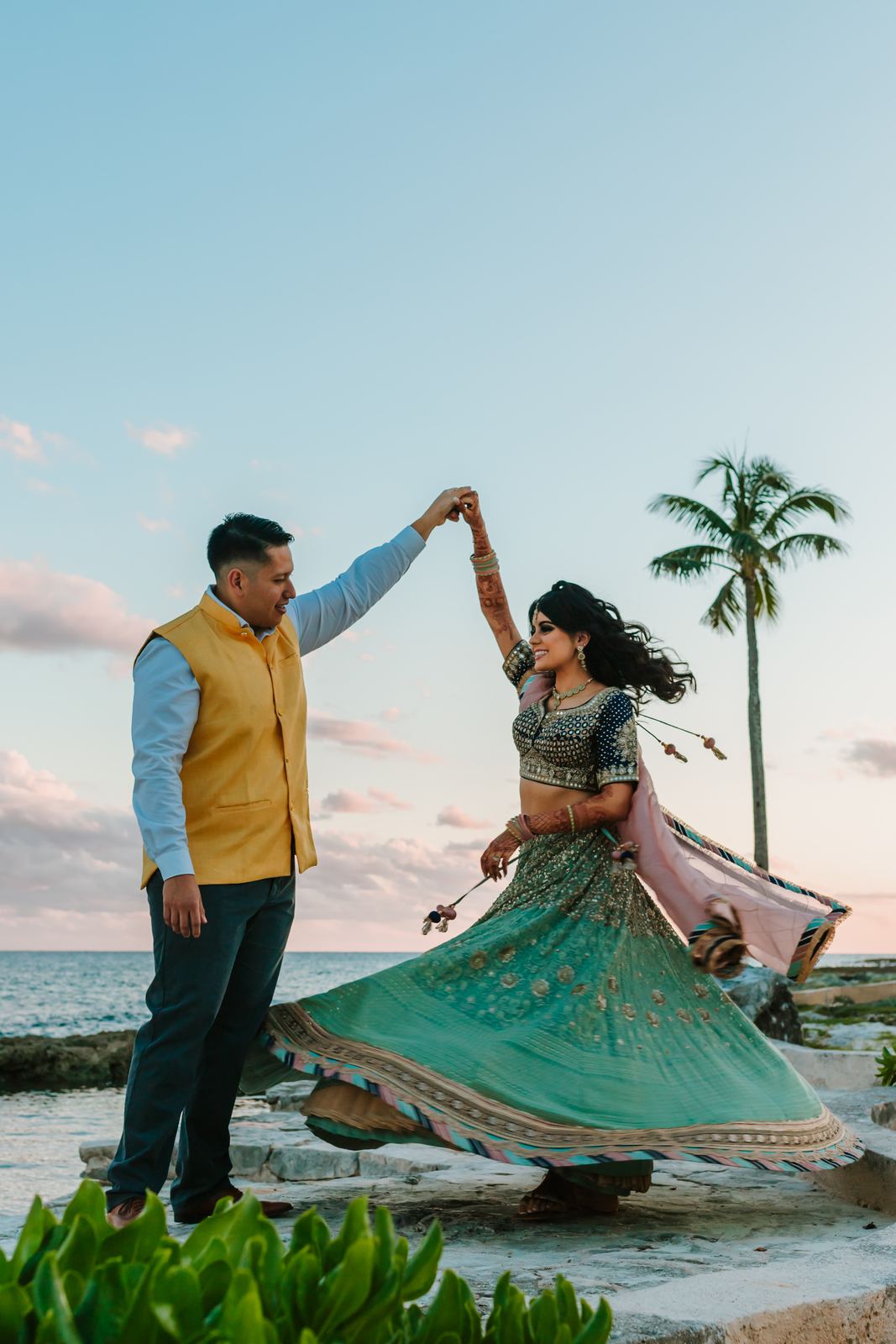 Bride's lehenga flaring mid-twirl against the sky