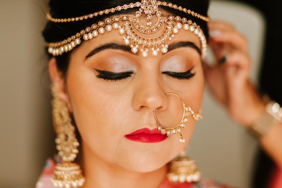 Bride in bridal jewellery with eyes closed, getting ready