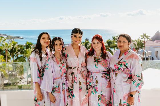 Bridal party in matching robes on an ocean-view terrace