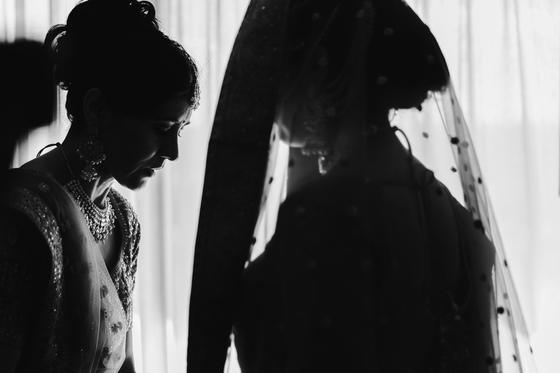 Black and white silhouette of the bride in her veil