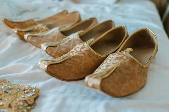 The groom's gold juttis set out before dressing