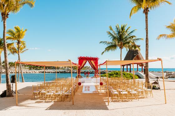 Empty mandap and ceremony chairs facing the Caribbean